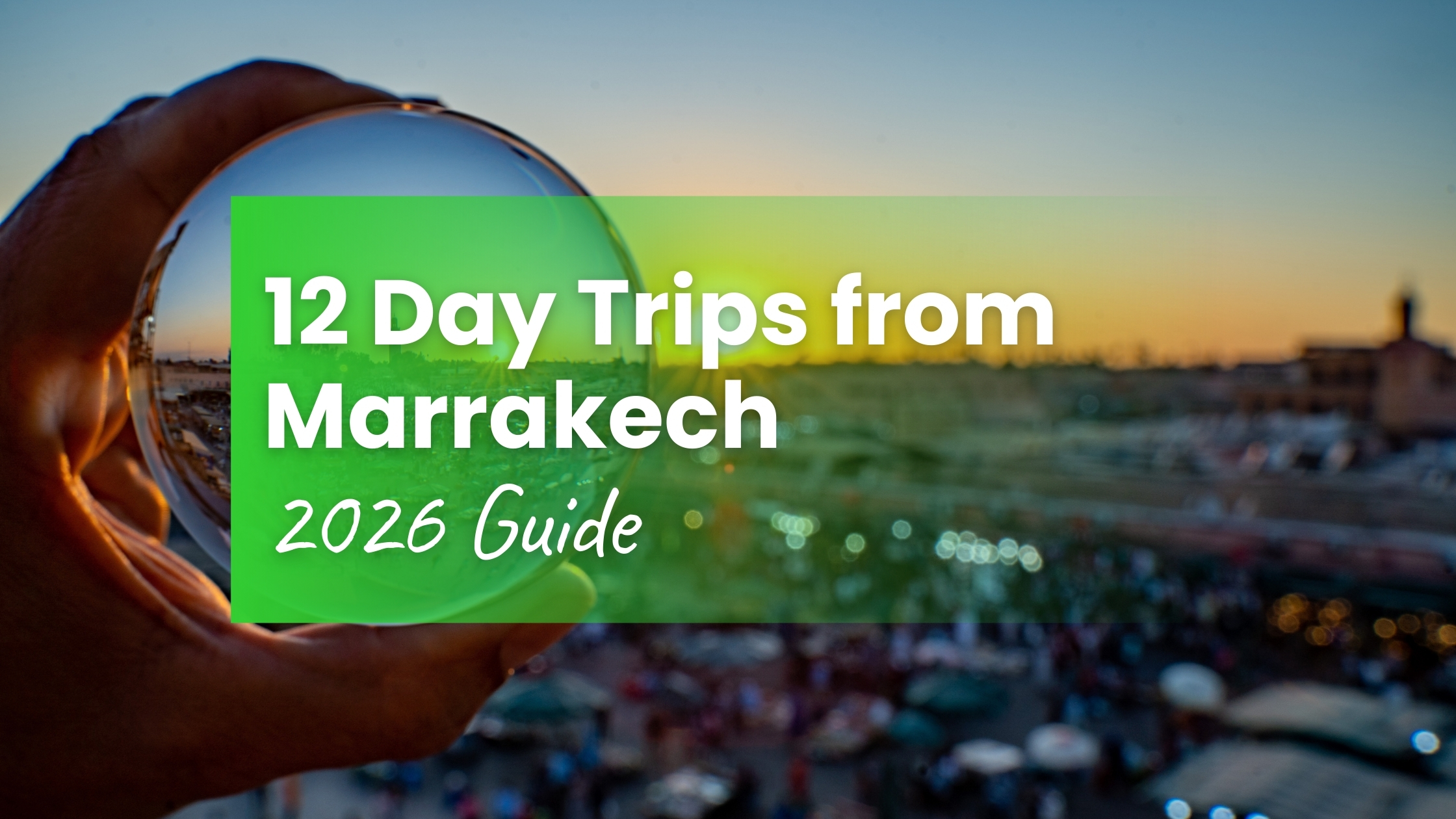 Hand holding crystal ball reflecting Djemaa el-Fna square at sunset — 12 day trips from Marrakech