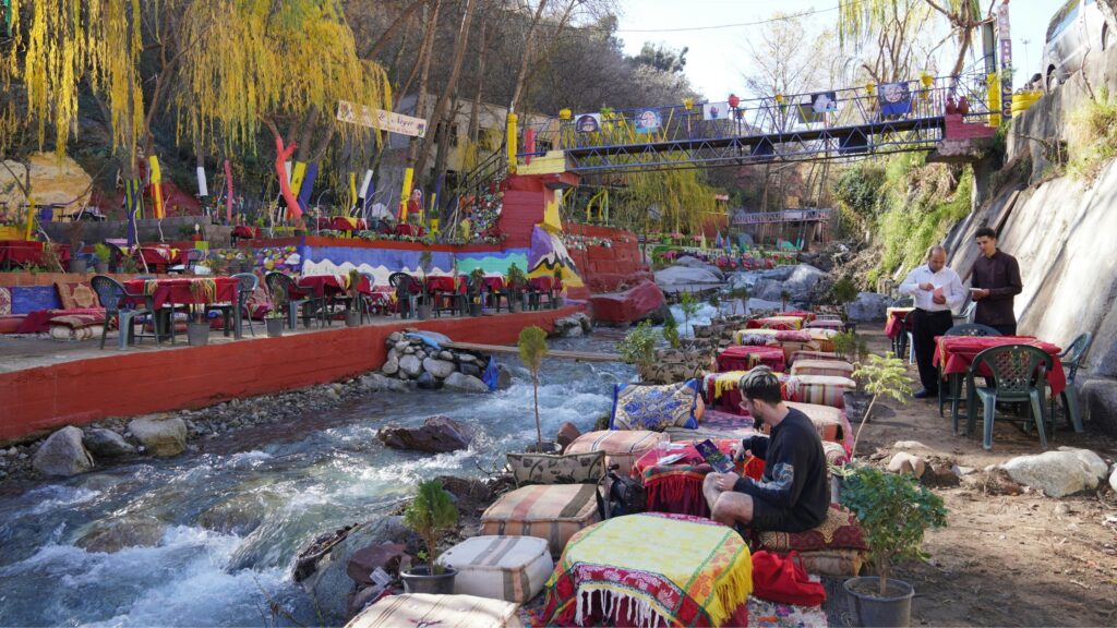 Tourist relaxing at a traditional riverside cafe in Setti Fatma during an Ourika Valley day trip from Marrakech